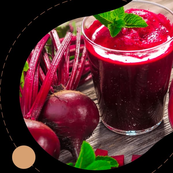 Freshly blended beetroot smoothie with mint garnish, surrounded by whole beetroots and stems.